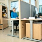 Offizz Floor Screens shown in use in an work environment with a person at a desk