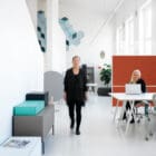 Offizz Floor Screens shown in use in a large enterprise work environment with a person at a desk and people walking past