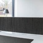 HEY-SIGN Table module Wave in use on a desk in a dark version along a wall