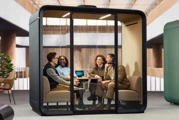 Framery Four with people talking inside inside a large open workspace
